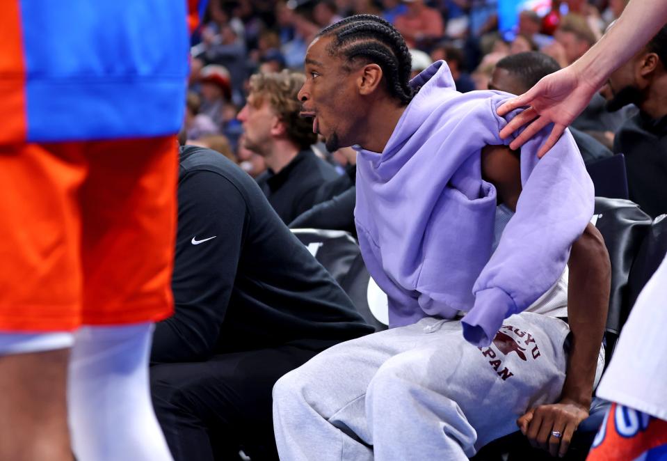 Injured Thunder guard Shai Gilgeous-Alexander celebrates from the bench during Friday night's win against the Suns at Paycom Center.