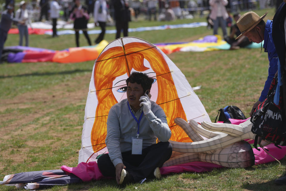 A participant rests during during the 41st International Kite Festival in Weifang, Shandong Province of China, Saturday, April 20, 2024. (AP Photo/Tatan Syuflana)