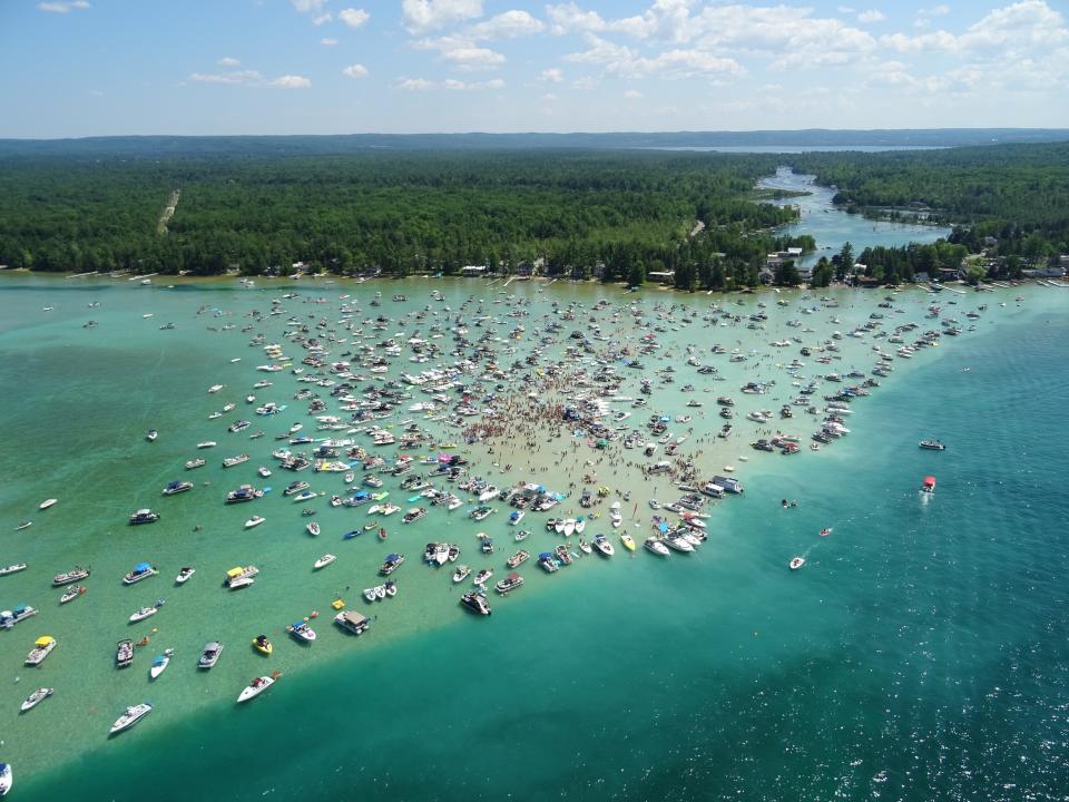 Anyone who attended a Fourth of July party at Torch Lake Sandbar over the holiday weekend is being asked to monitor themselves for symptoms after several attendees tested positive.