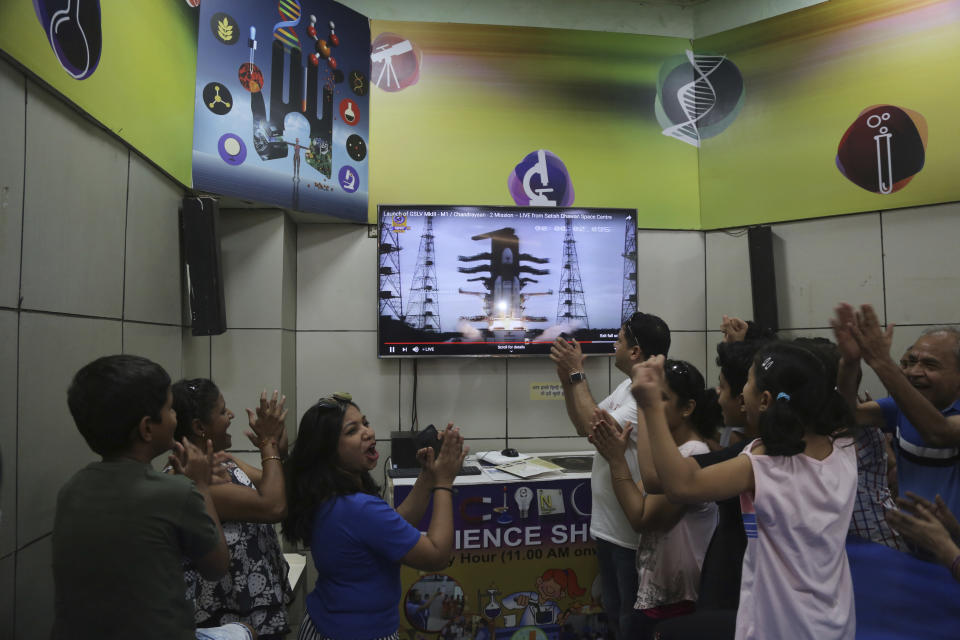 Indians cheer as they watch the on screen the lift off of Indian Space Research Organization (ISRO)'s Geosynchronous Satellite launch Vehicle (GSLV) MkIII carrying Chandrayaan-2 in Mumbai, India, Monday, July 22, 2019. India successfully launched an unmanned spacecraft to the far side of the moon on Monday, a week after aborting the mission due to a technical problem. (AP Photo/Rafiq Maqbool)