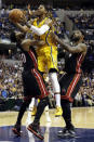 Indiana Pacers forward Paul George, center, shoots between Miami Heat defenders Udonis Haslem, left, and LeBron James during the second half of an NBA basketball game in Indianapolis, Wednesday, March 26, 2014. The Pacers won 84-83. (AP Photo/AJ Mast)