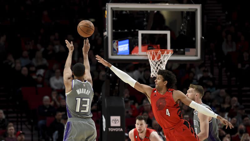 Sacramento Kings forward Keegan Murray, left, hits a shot over Portland Trail Blazers guard Matisse Thybulle during the second half of an NBA basketball game in Portland, Ore., Wednesday, March 29, 2023. The Kings won 120-80.