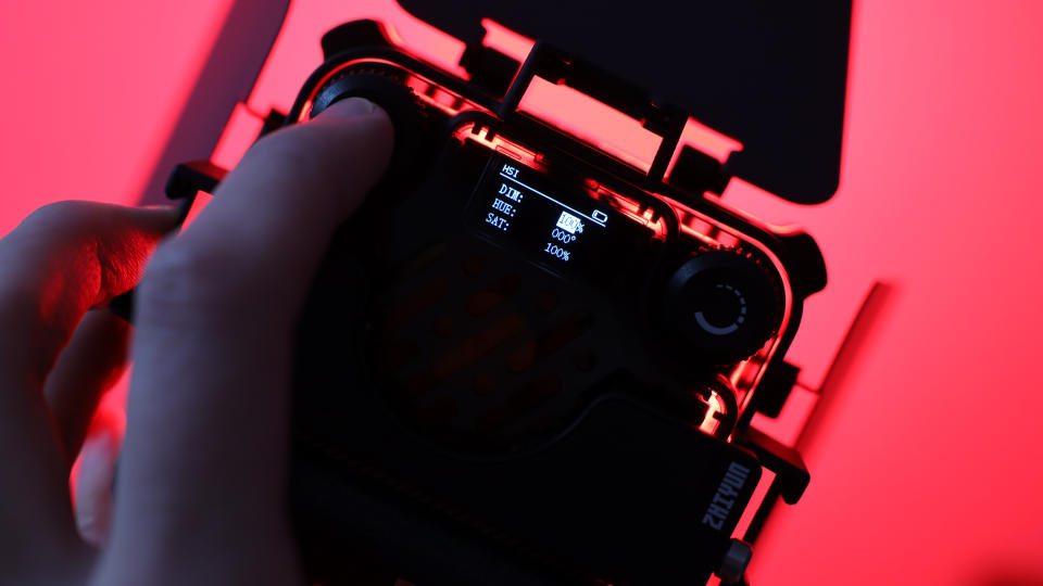 Zhiyun FIVERAY M20C LED panel lit up red and held in a hand