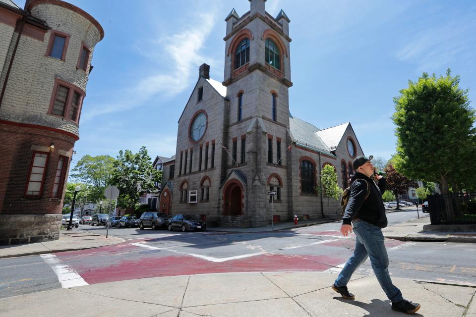 A man walks past the Pilgrim United Church of Christ on Purchase Street in New Bedford.