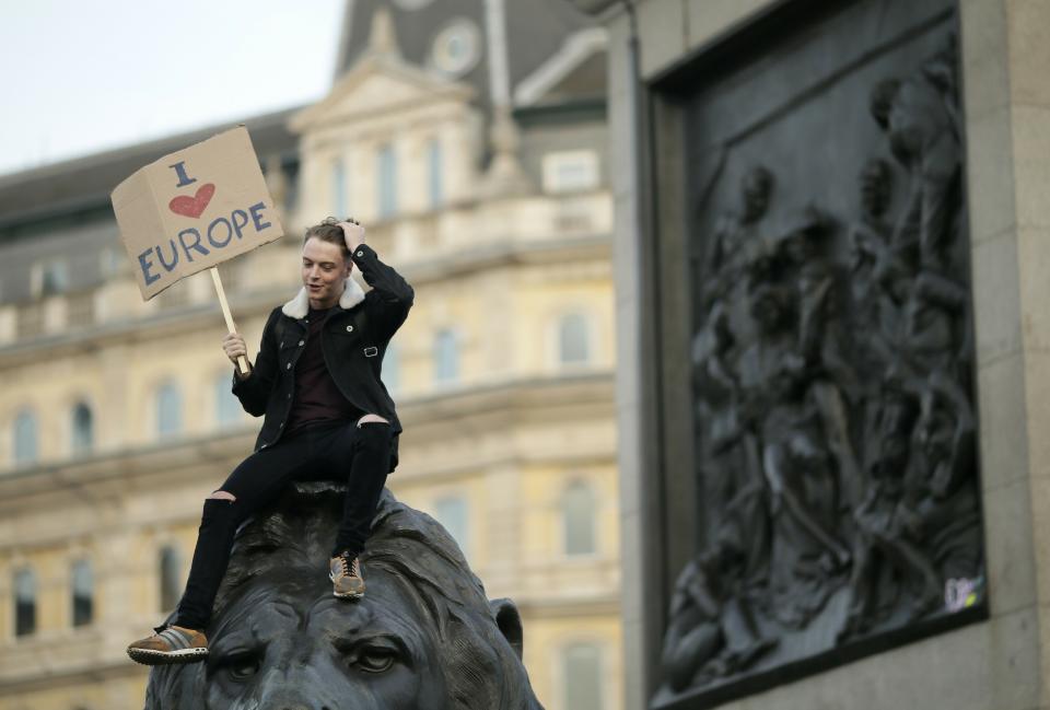 A demonstrator sits on one of the lions in Trafalgar Square during a Peoples Vote anti-Brexit march in London, Saturday, March 23, 2019. The march, organized by the People's Vote campaign is calling for a final vote on any proposed Brexit deal. This week the EU has granted Britain's Prime Minister Theresa May a delay to the Brexit process. (AP Photo/Tim Ireland)