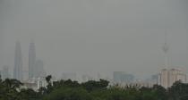 Haze covers Petronas Twin Towers (L) and KL Tower (R) in Kuala Lumpur, on June 16, 2013. Singapore urged Indonesia to take "urgent measures" as severe air pollution from a rash of forest fires on Sumatra island choked the densely populated city-state