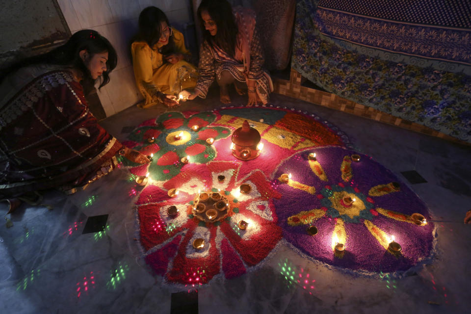 Hindu women attend a ceremony to celebrate Diwali, the festival of lights, at a temple in Karachi, Pakistan, Friday, Nov. 4, 2021. The Hindu festival of lights, Diwali celebrates the spiritual victory of light over darkness. (AP Photo/Fareed Khan)