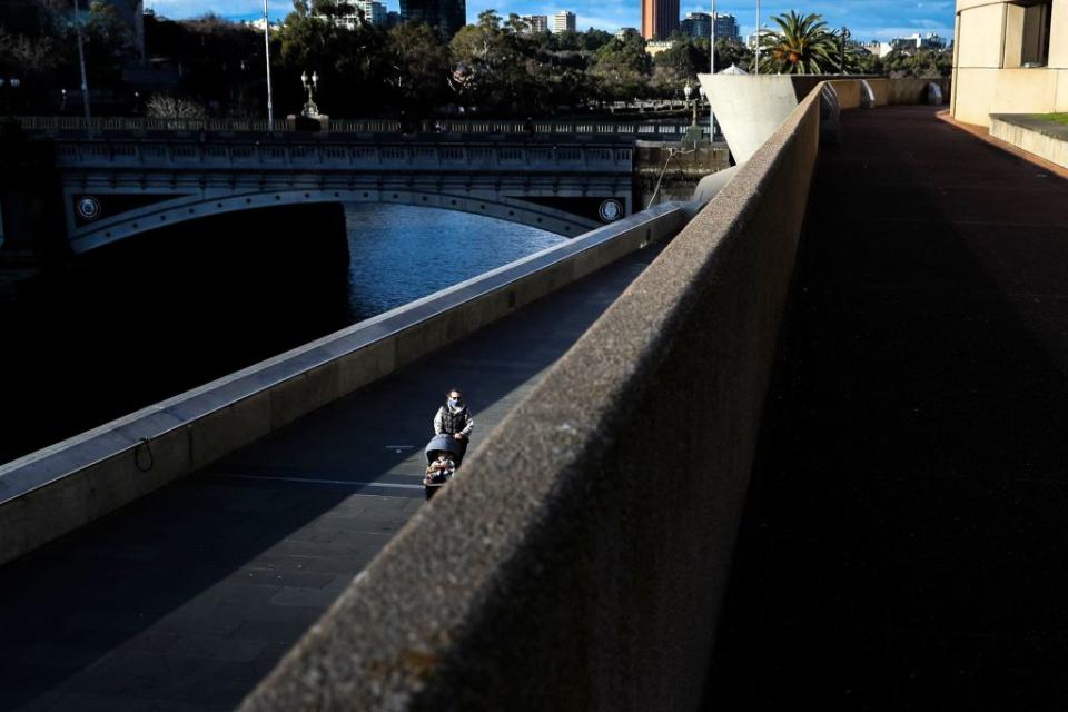 A face mask-clad woman walking through Southbank in Melbourne following a fresh lockdown amid a resurgence in coronavirus cases. 