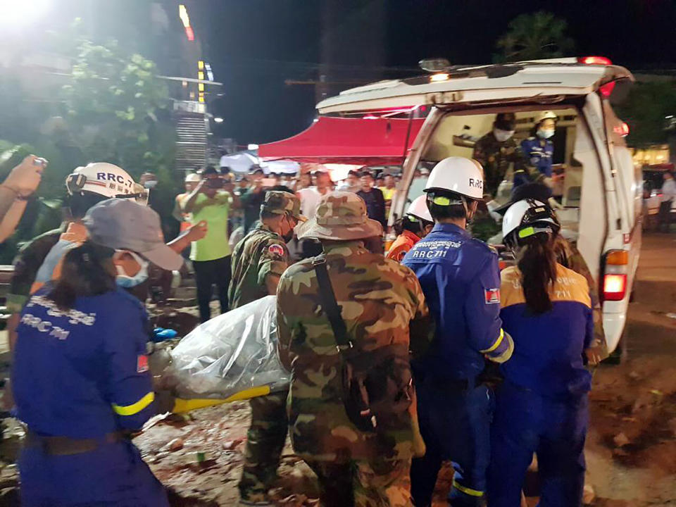 In this Sunday, June 23, 2019, photo provided by Preah Sihanouk provincial authorities, rescuers enter a victim body onto an ambulance at a site of a collapse in Preah Sihanouk province, Cambodia. Rescuers on Monday were continuing to search the rubble of a building that collapsed while under construction in a Cambodia beach town, killing dozens of workers as they slept in the unfinished condominium that was doubling as their housing. (Preah Sihanouk provincial authorities via AP)