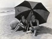 <p>Joan Crawford sits under a beach umbrella with her new husband, Douglas Fairbanks Jr.</p>