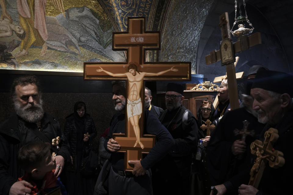 Orthodox Christian worshippers carry crosses during the Good Friday procession at the Church of the Holy Sepulcher, where many Christians believe Jesus was crucified, buried and rose from the dead, in Jerusalem's Old City, Friday, April 14, 2023. (AP Photo/Mahmoud Illean)