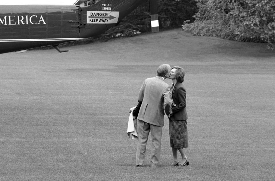 FILE - In this May 10, 1979 file photo, President Jimmy Carter pauses to kiss first lady Rosalynn Carter as he boards a helicopter in Washington, for the trip from the White House to Camp David, Maryland. Sign at upper left is on the tail of the helicopter. Jimmy Carter and his wife Rosalynn celebrate their 75th anniversary this week on Thursday, July 7, 2021. (AP Photo/Barry Thumma, File)