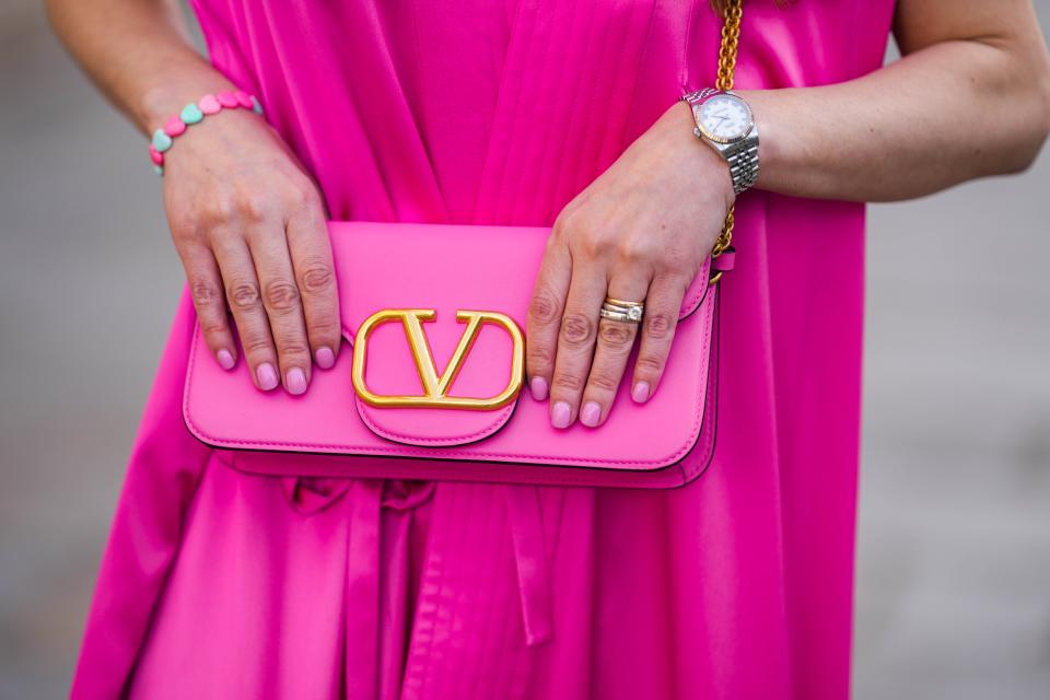 Magenta clutch, nails, in hands