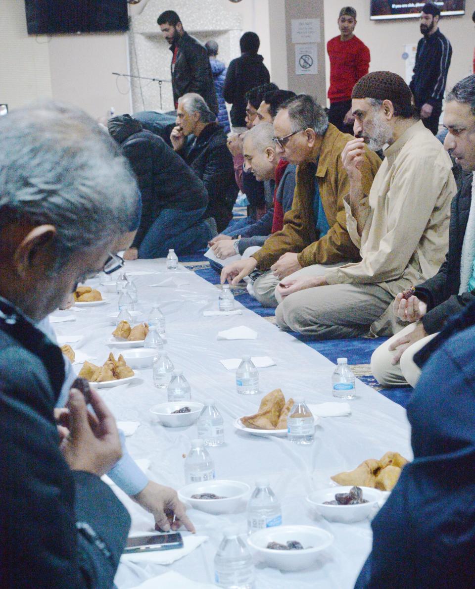 Men begin to eat to observe the iftar, or breakfast, breaking the daily fast during Ramadan, at the Erie Masjid on April 1, 2023. Those of the Muslim faith fast from sunrise to sunset during Ramadan, which began on March 22 and ends on April 21. Women in the Masjid were eating in a separate area of the building.