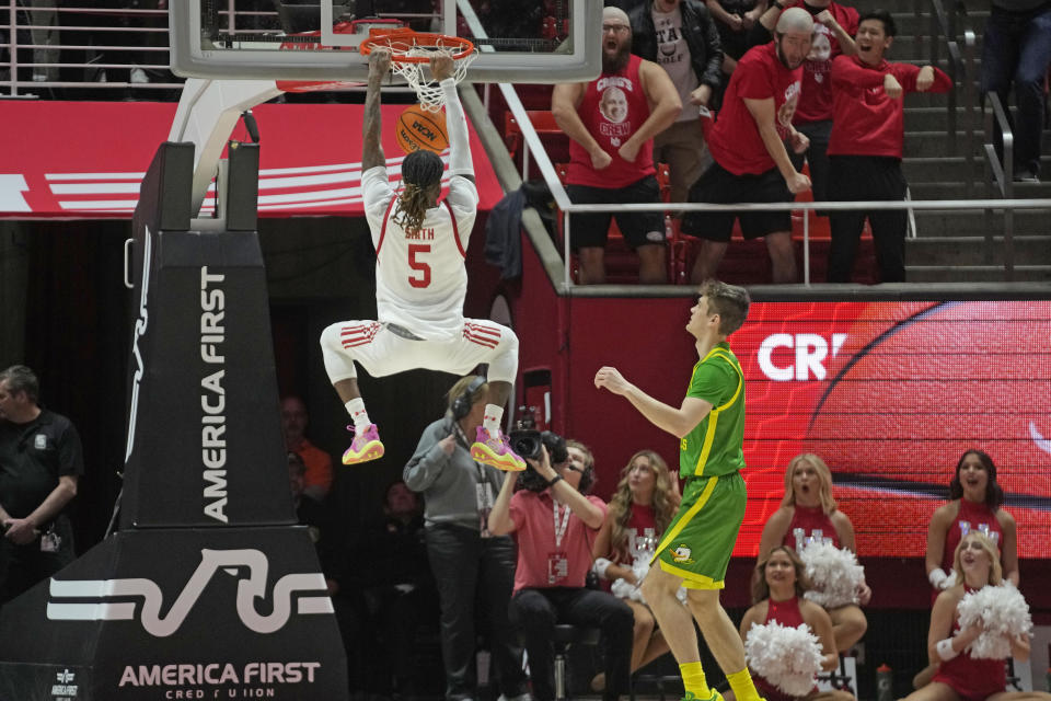 Utah guard Deivon Smith (5) dunks the ball as Oregon guard Brennan Rigsby, right, looks on during the first half of an NCAA college basketball game, Sunday, Jan. 21, 2024, in Salt Lake City. (AP Photo/Rick Bowmer)