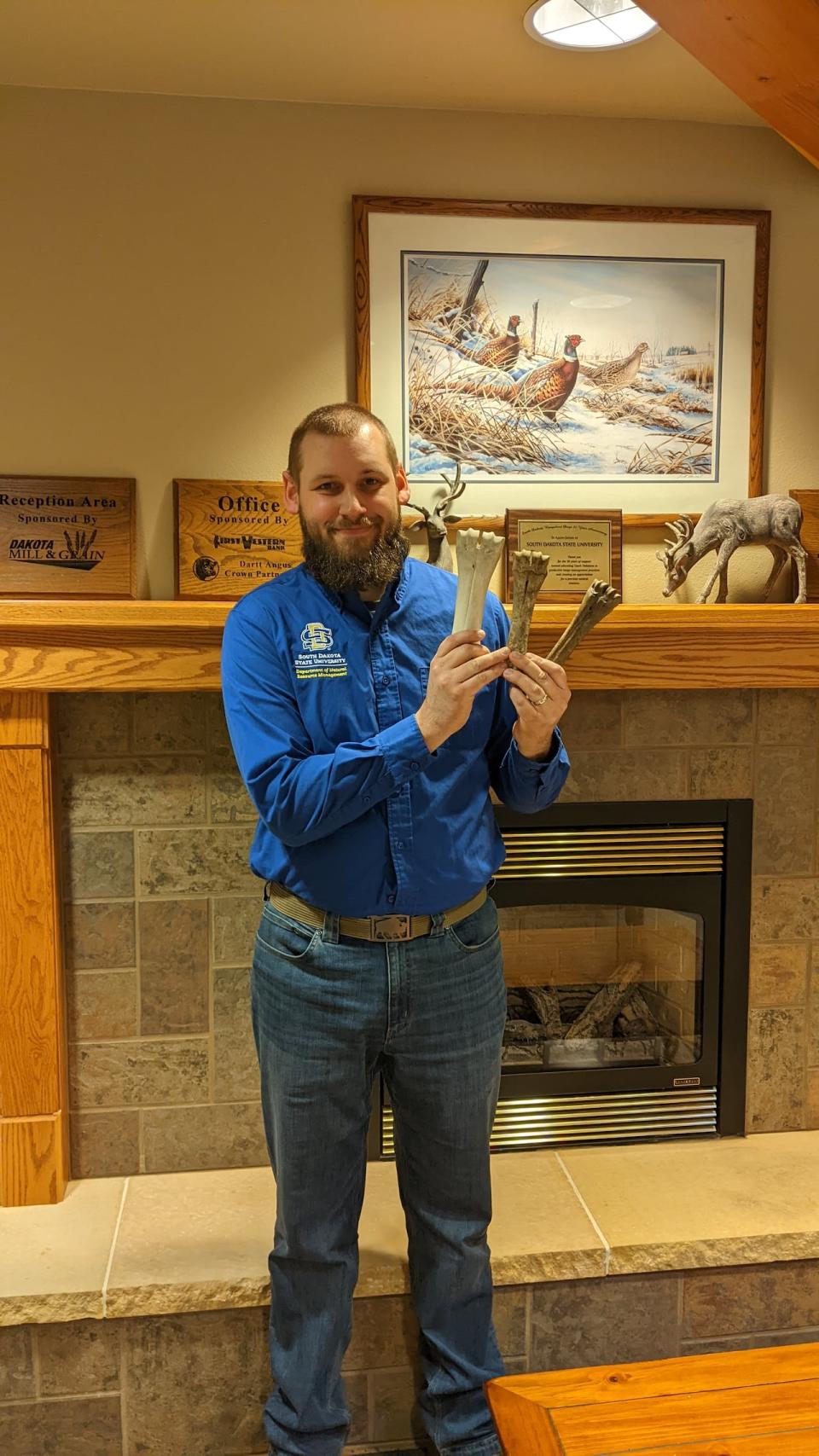 Jeff Martin, bison specialist at South Dakota State University, holds two bones from P.E.I.  on the right, and a bison bone on the left.