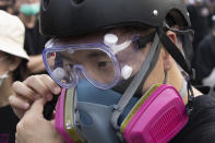 In this Aug. 16, 2019, photo, Wayne, a 33-year-old self-described “front line” protester, adjusts his gas mask stands along with other demonstrators in Tai Po, on Hong Kong's outskirts. Hong Kong's protest movement has reached a moment of reckoning after protesters occupying the airport held two mainland Chinese men captive, and pro-democracy lawmakers and fellow demonstrators question whether the whole operation has gone too far. (AP Photo/Vincent Thian)