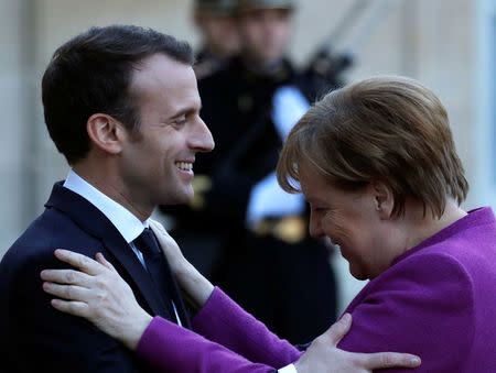 French President Emmanuel Macron welcomes German Chancellor Angela Merkel as she arrives for a meeting at the Elysee Palace in Paris, France, March 16, 2018. REUTERS/Christian Hartmann