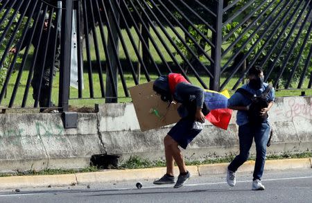 An opposition supporter covers another one after he was injured outside an air force base during clashes with riot police forces at a rally against Venezuelan President Nicolas Maduro's government in Caracas, Venezuela June 22, 2017. REUTERS/Carlos Garcia Rawlins