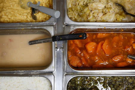 Side dishes including (clockwise from top right) cabbage, sweet potatoes, collared greens, rice, beans and macaroni-and-cheese are ready to be served at Ms. Girlee's Soul Food Restaurant in Memphis, Tennessee, U.S., March 29, 2018. The restaurant is owned by Henry Leach and his family. Leach, who participated in the strike 50 years ago, said Martin Luther King came to the city for justice, not violence. "He came to help us get what we wanted. Like I tell you, he became like a father to us," the former sanitation worker said recently. REUTERS/Jonathan Ernst