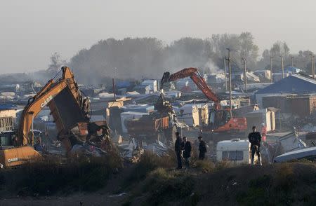 Bulldozers are used to tear down makeshift shelters and tents during the dismantlement of the camp called the "Jungle" in Calais, France, October 27, 2016. REUTERS/Philippe Wojazer