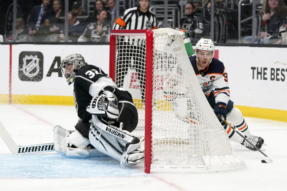 Edmonton Oilers center Connor McDavid, right, sneaks around the net before scoring on Los Angeles Kings goaltender Jonathan Quick during the first period in Game 6 of an NHL hockey Stanley Cup first-round playoff series Thursday, May 12, 2022, in Los Angeles. (AP Photo/Mark J. Terrill)