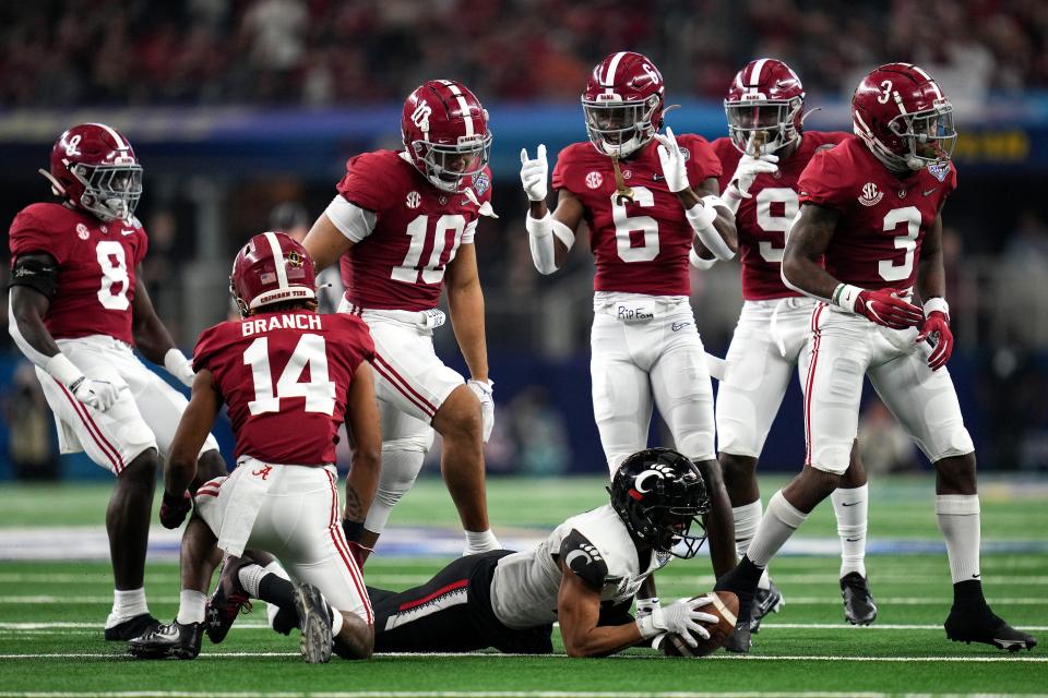 Alabama players celebrate after tackling Cincinnati wide receiver Tyler Scott in the second quarter during the College Football Playoff semifinal game at the 86th Cotton Bowl Classic.