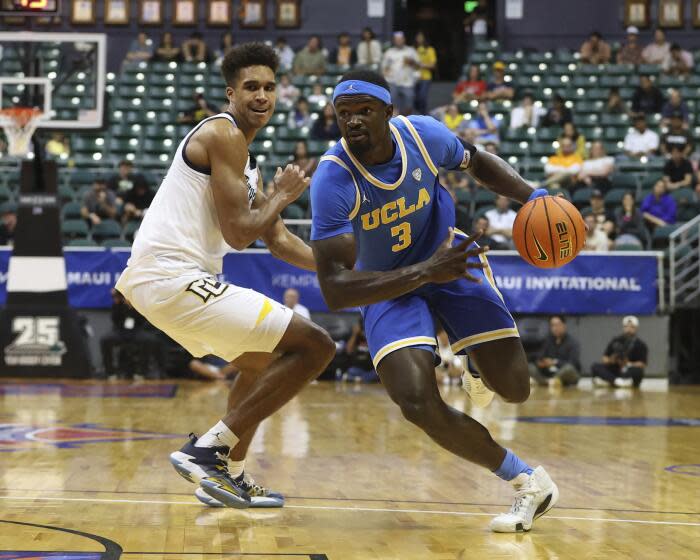 UCLA forward Adem Bona gets past Marquette forward Oso Ighodaro on Monday in Honolulu.