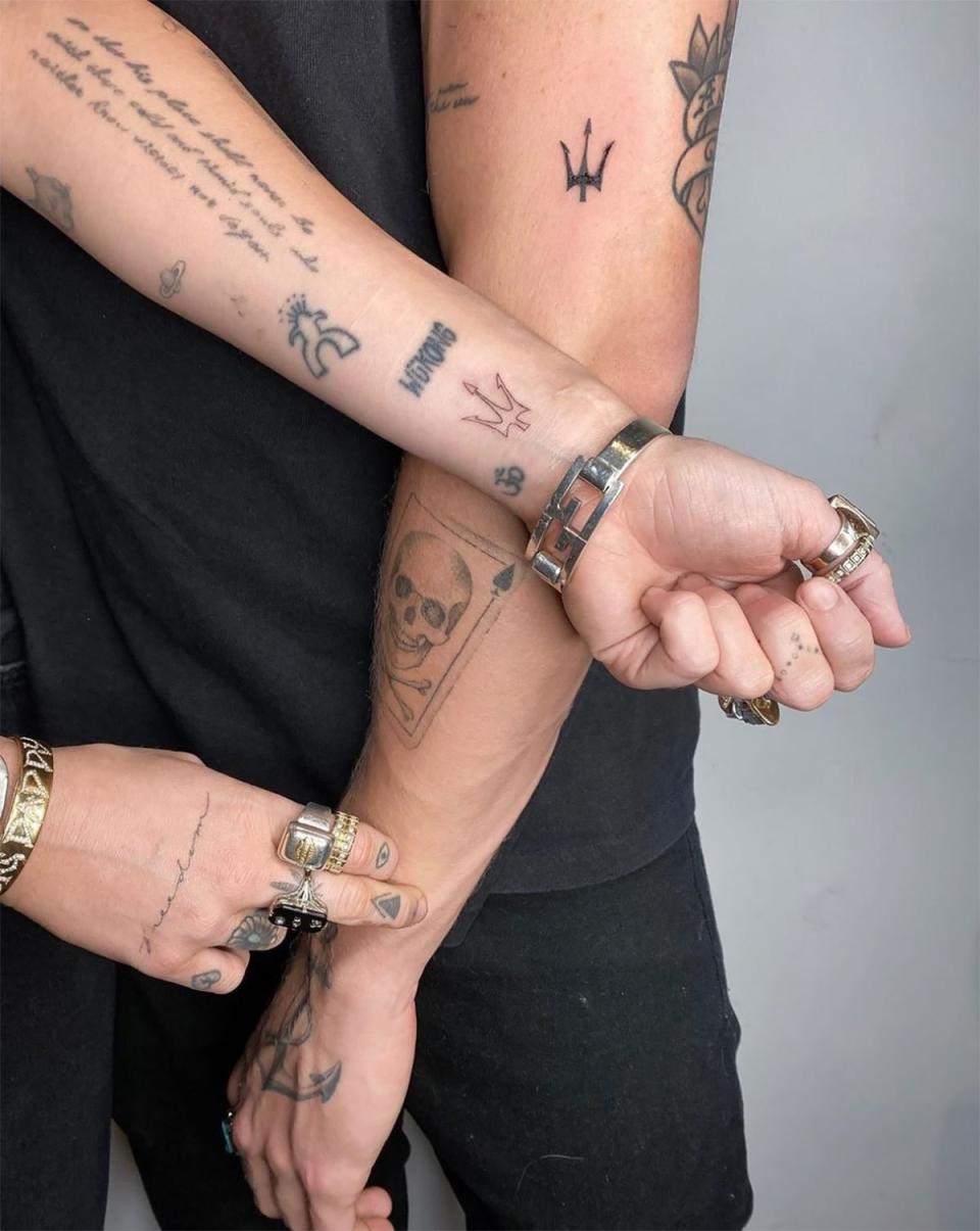 Miley Cyrus and Cody Simpson with matching trident tattoos