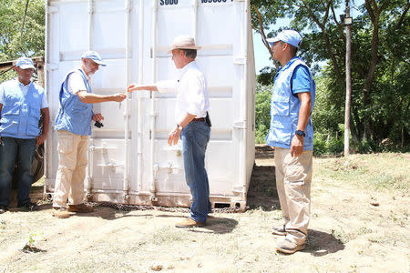 Colombia's President Juan Manuel Santos gives the keys for the last container with surrendered weapons delivered by FARC rebels to a UN observer in La Guajira, Colombia August 15, 2017. Colombian Presidency/Handout via REUTERS