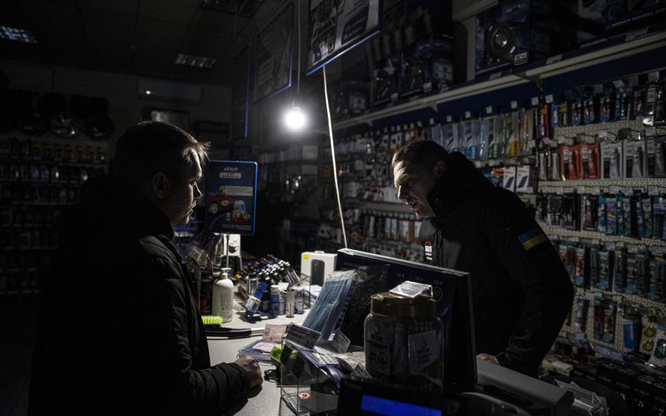 KYIV, UKRAINE - NOVEMBER 21: A man works in the dark during a power outage in Kyiv, Ukraine on November 21, 2022. As the Russian forces hit energy infrastructures since October, Ukrainian shops are obliged to use generators in order to stay in business. Power outages take place as the repair of the energy infrastructures continue intensively. (Photo by Metin Aktas/Anadolu Agency via Getty Images) - Metin Aktas/Anadolu Agency via Getty Images