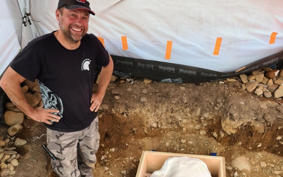 Metal detectorist Mariusz Stepien stands next to the hoard found in the Scottish Borders - Crown Office Communications/PA