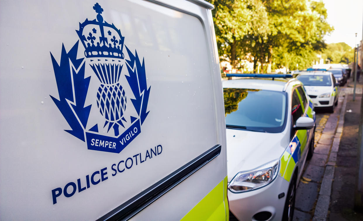 Edinburgh, Scotland, UK - July 16, 2014: The Police Scotland logo on the side of a police van, with other police vehicles in the background. Police Scotland was established in 2013 as an amalgamation of eight regional police forces across the country. 