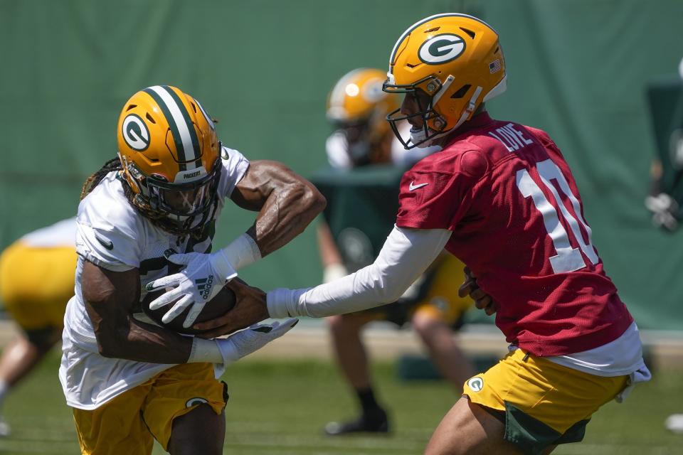 Green Bay Packers' Jordan Love hands off to Aaron Jones during an NFL football minicamp Tuesday, June 8, 2021, in Green Bay, Wis. (AP Photo/Morry Gash)