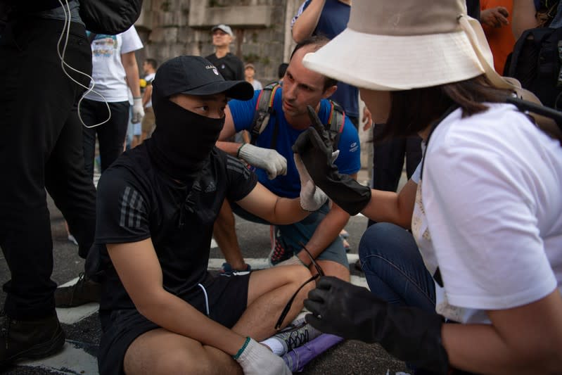 People clearing makeshift road barricades placed by protesters get into an argument with protesters outside the University of Hong Kong in Hong Kong