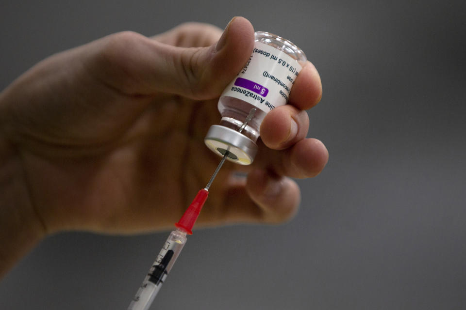 FILE - In this Friday, Feb. 19, 2021 file photo, a pharmacist prepares a syringe from a vial of the AstraZeneca coronavirus vaccine during preparations at the Vaccine Village in Antwerp, Belgium. At least a dozen countries including Germany, France, Italy and Spain have now temporarily suspended their use of AstraZeneca's coronavirus vaccine after reports last week that some people in Denmark and Norway who got a dose developed blood clots, even though there's no evidence that the shot was responsible. The European Medicines Agency and the World Health Organization say the data available don't suggest the vaccine caused the clots and that people should continue to be immunized. Here's a look at what we know — and what we don't.(AP Photo/Virginia Mayo, File)