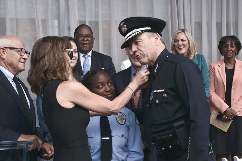 FILE - Michael Moore gets pinned by his wife Cindy after being sworn in as the new Los Angeles Chief at the police academy on Thursday, June 28, 2018. The Los Angeles police chief announced his retirement Friday, Jan. 12, 2024 in an unexpected departure as the head of one of the nation’s largest law enforcement agencies.(AP Photo/Richard Vogel, File).