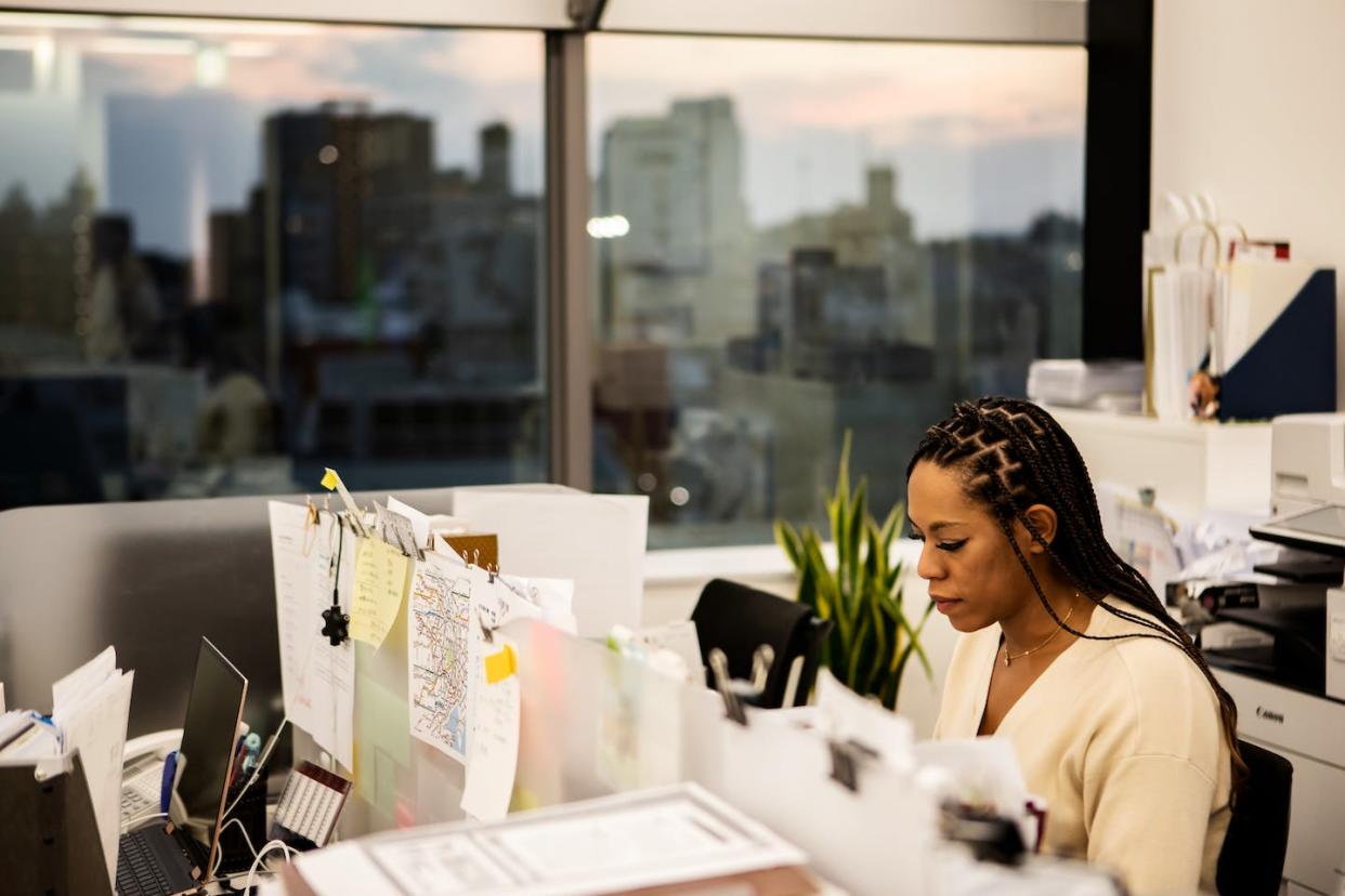 Racial trauma can cause feelings of isolation among Black people. <a href="https://www.gettyimages.com/detail/photo/female-employee-working-overtime-in-the-evening-royalty-free-image/1496339990?phrase=black+woman+corporation&adppopup=true" rel="nofollow noopener" target="_blank" data-ylk="slk:Taiyou Nomachi/Getty Images;elm:context_link;itc:0;sec:content-canvas" class="link ">Taiyou Nomachi/Getty Images</a>