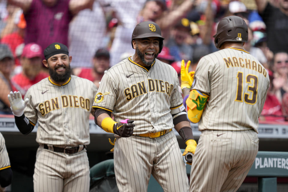 San Diego Padres Manny Machado (13) celebrates with Nelson Cruz, center, after hitting a two-run home run during the seventh inning of a baseball game against the Cincinnati Reds Saturday, July 1, 2023, in Cincinnati. (AP Photo/Jeff Dean)