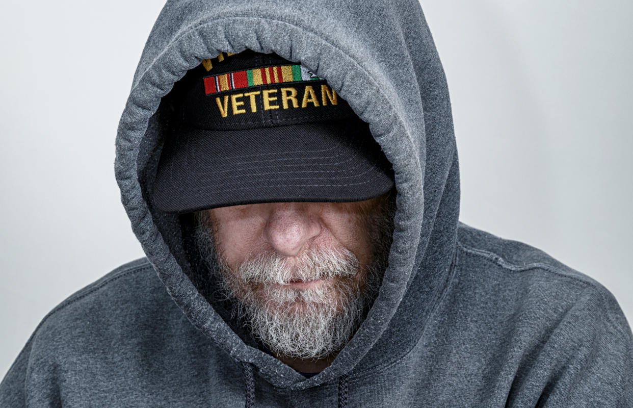 A military veteran is looking down with his partially obscured face showing a serious facial expression. (Photo: Getty Images)