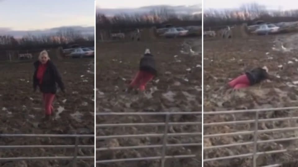 Going.. going.. gone! This woman's son records her struggling to get out of the mud. Photo: YouTube