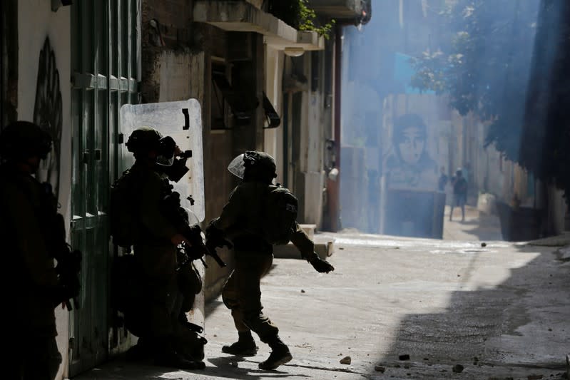 Israeli soldiers take position during an anti-Israel protest by Palestinians in al-Arroub refugee camp, in the Israeli-occupied West Bank