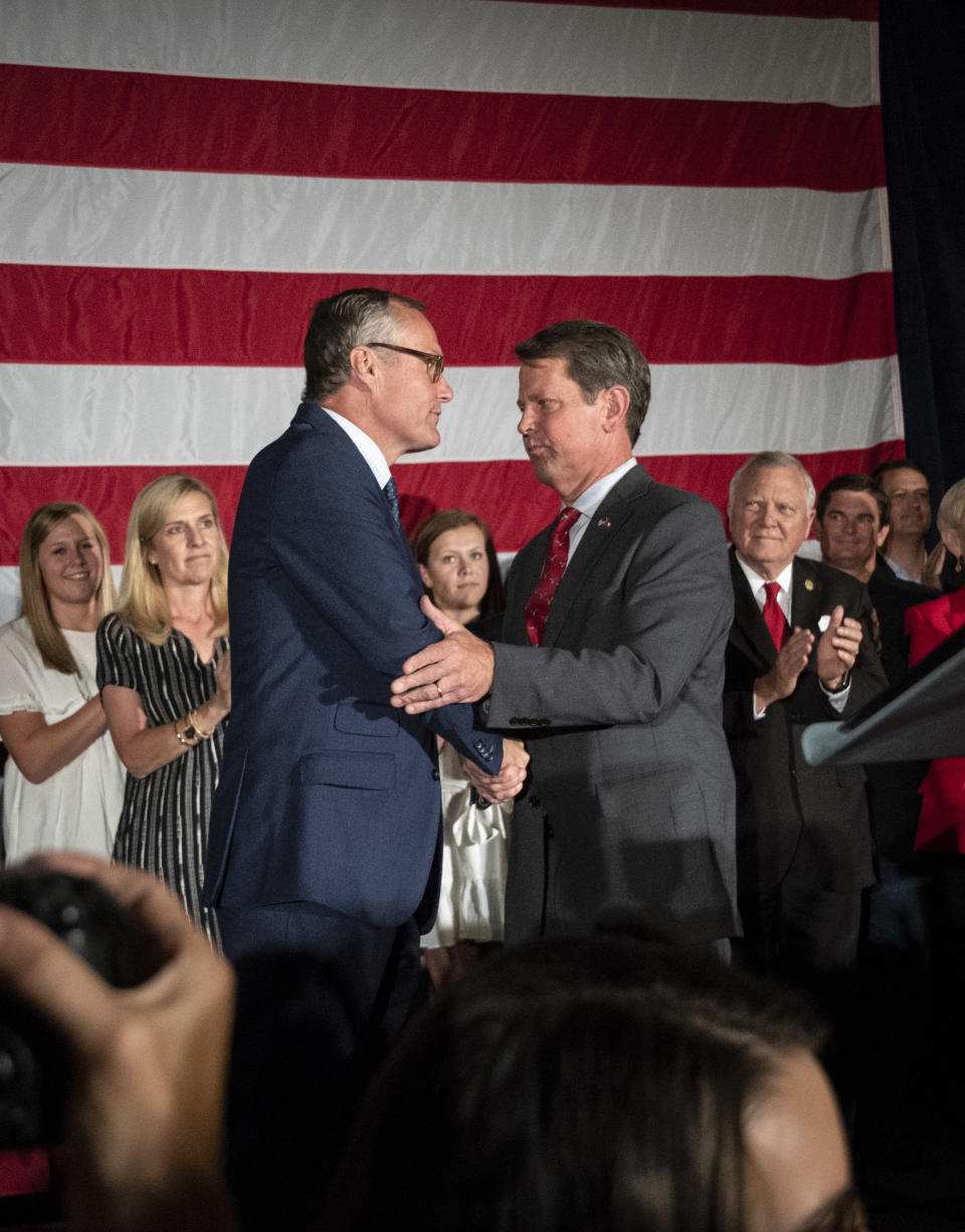 Georgia Republican Lt. Gov. Casey Cagle, left, and Secretary of State Brian Kemp celebrate during a unity rally, Thursday, July 26, 2018, in Peachtree Corners, Ga. The pair faced off in a heated gubernatorial runoff race which Kemp won. (AP Photo/John Amis)