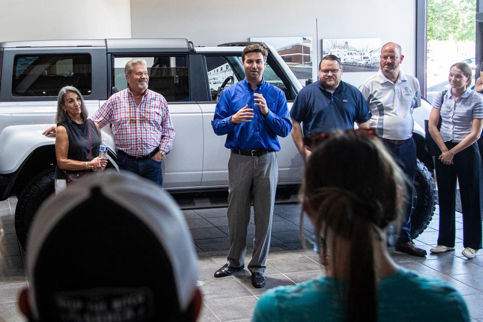 Tom Butman, general manager of Gene Butman Ford, speaks to students during the an event in partnership with Ford at the dealership in Ypsilanti on Friday, May 31, 2024 to donate four 2024 flood damaged Mustangs to local schools that offer automotive technology programs.