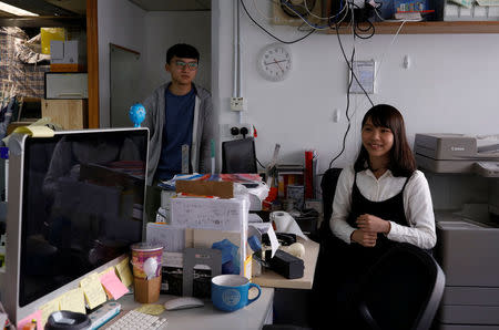 Student activist Agnes Chow reacts next to student activist Isaac Cheng (L) during her interview ahead of her campaign to join Legislative Council by election, at Demosisto party's office in Hong Kong, China December 8, 2017. REUTERS/Tyrone Siu