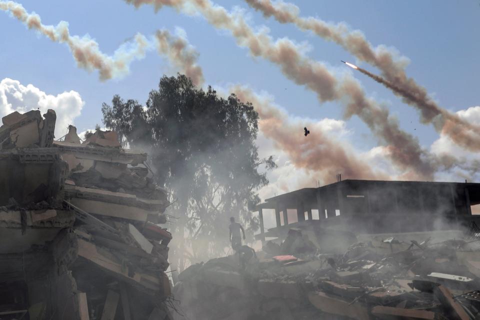 Rockets are fired from the Gaza Strip toward Israel over destroyed buildings following Israeli airstrikes on Gaza City (Copyright 2023 The Associated Press. All rights reserved.)