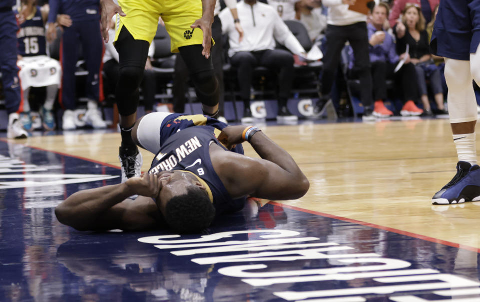 New Orleans Pelicans forward Zion Williamson, left, reacts after hitting the floor on a play where Utah Jazz guard Jordan Clarkson blocked his shot during the second half of an NBA basketball game Sunday, Oct. 23, 2022, in New Orleans. Williamson left the game. (Scott Threlkeld/The Times-Picayune/The New Orleans Advocate via AP)