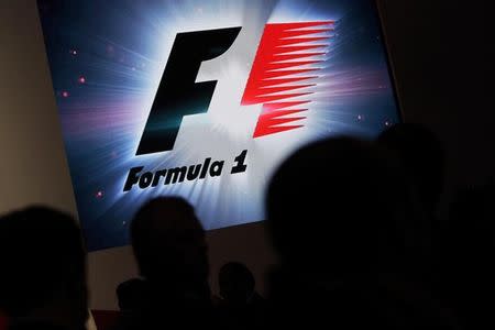 Reporters are silhouetted by a screen showing a F1 logo during a news conference to announce a Formula One race in Mexico City July 23, 2014. REUTERS/Daniel Becerril