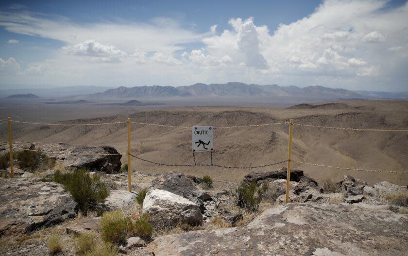 FILE - In this July 14, 2018, file photo, a sign warns of a falling danger on the crest of Yucca Mountain during a congressional tour near Mercury, Nev. Nevada is asking the federal Nuclear Regulatory Commission to restart its look at licensing the mothballed Yucca Mountain national radioactive waste repository, with the expectation that will finally end four decades of debate and kill it. (AP Photo/John Locher, File)