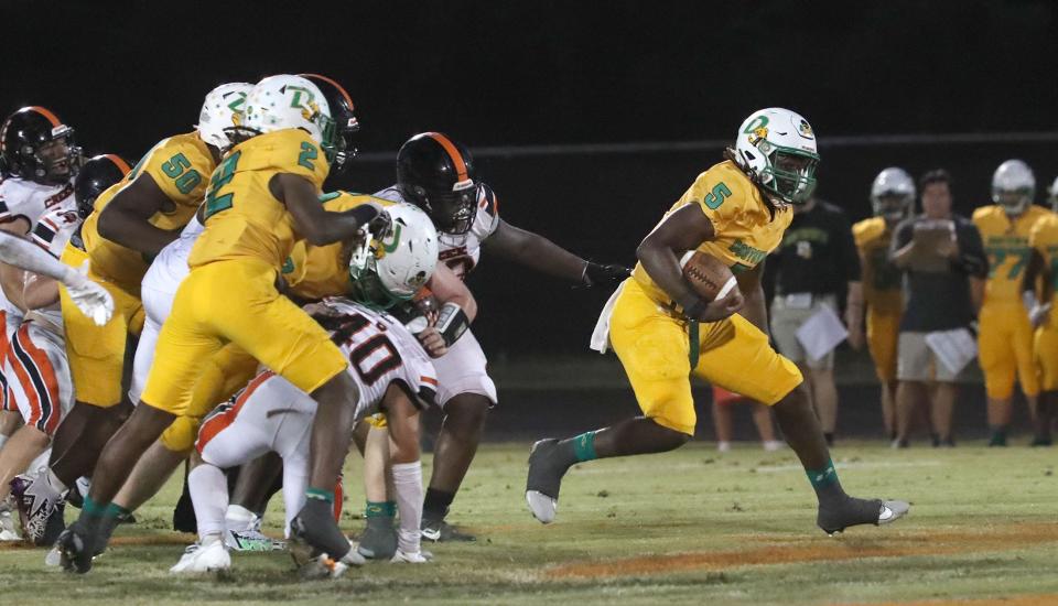 DeLand High's T.J. Moore #$ runs for some yards as Spruce Creek High gives chase, Friday September 29, 2023 in Port Orange.